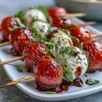 Bridal Shower Caprese Skewers with cherry tomatoes, fresh mozzarella, and basil leaves drizzled with balsamic glaze.